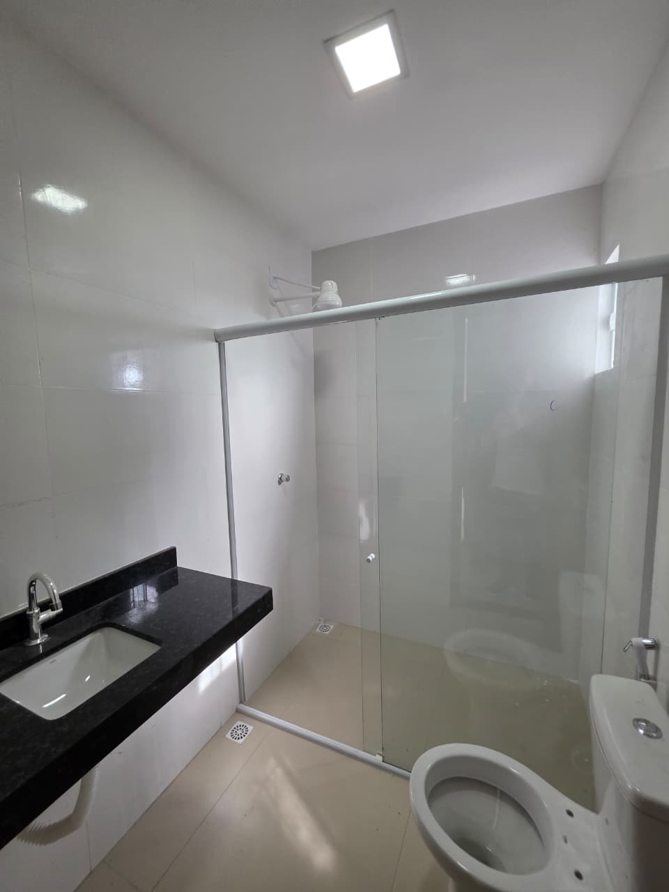 Banheiro com box de vidro e bancada em granito