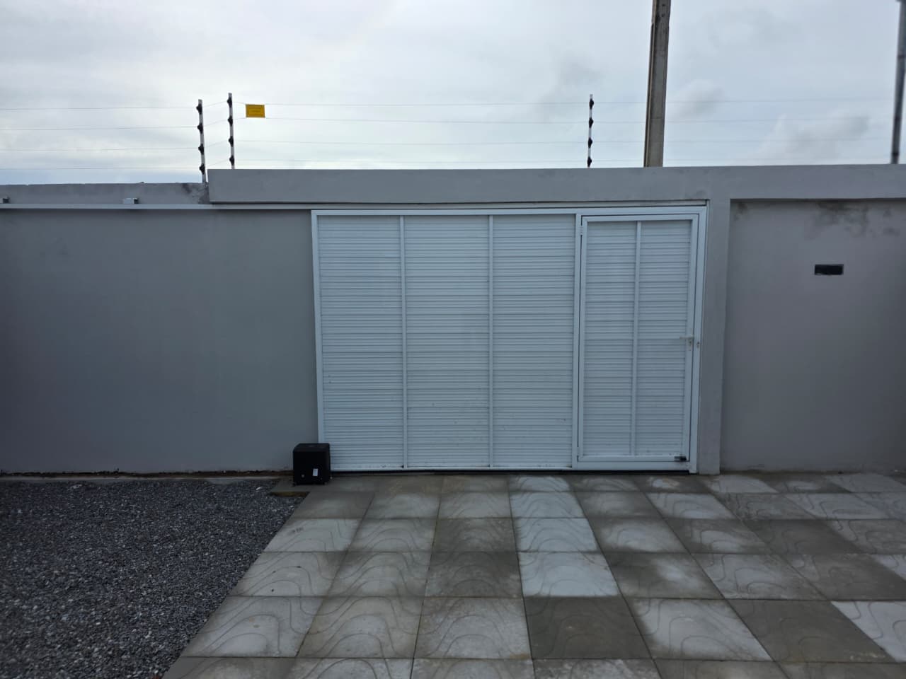 Garagem coberta com portão e cerca elétrica